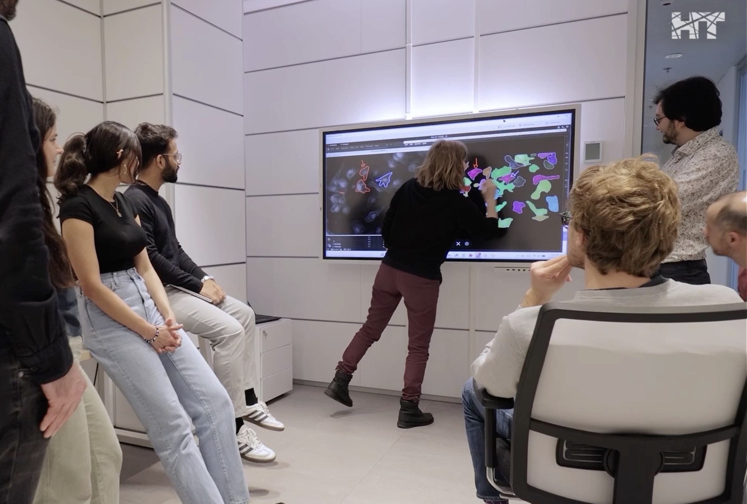 Members of the Scientific AI Flagship at HT reviewing AI-generated cell segmentation on a large interactive screen
